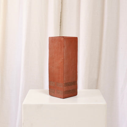 Three-quarter rear view showing banded base detail on square terracotta vase.