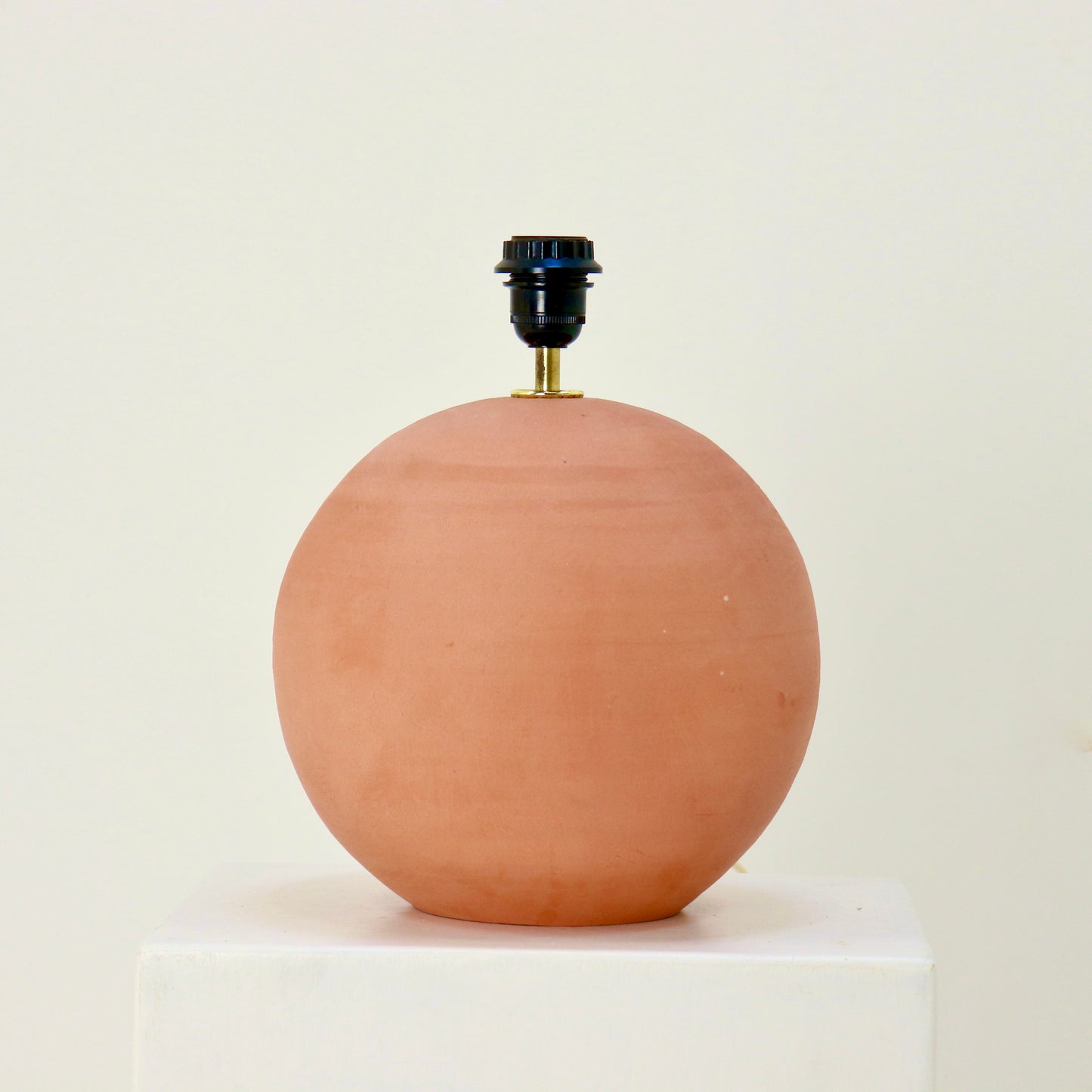 Minimal modern rustic table lamp on white plinth