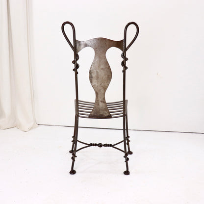 Sculptural iron chair with looped backrest