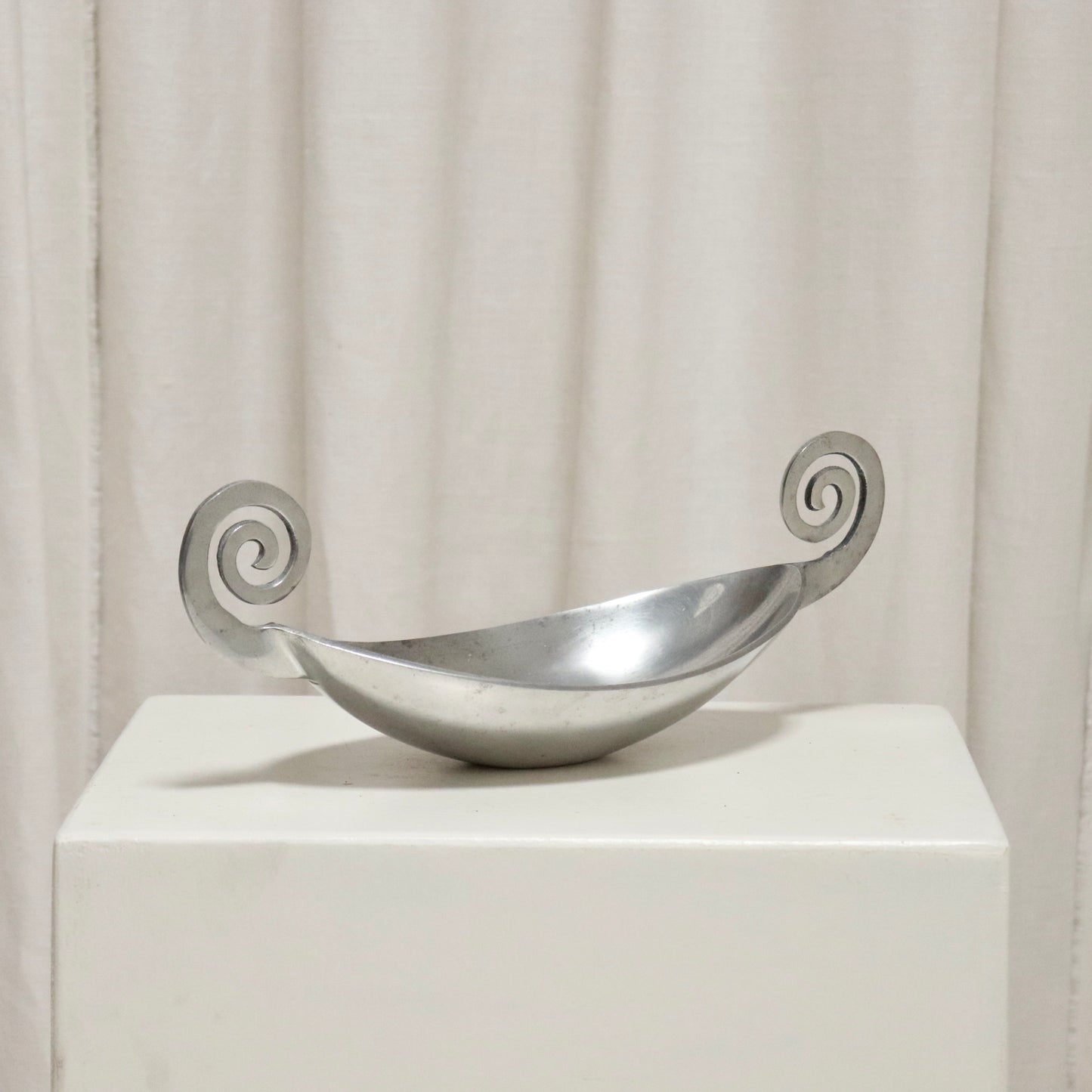 Front view of aluminium dish with twin volute handles.