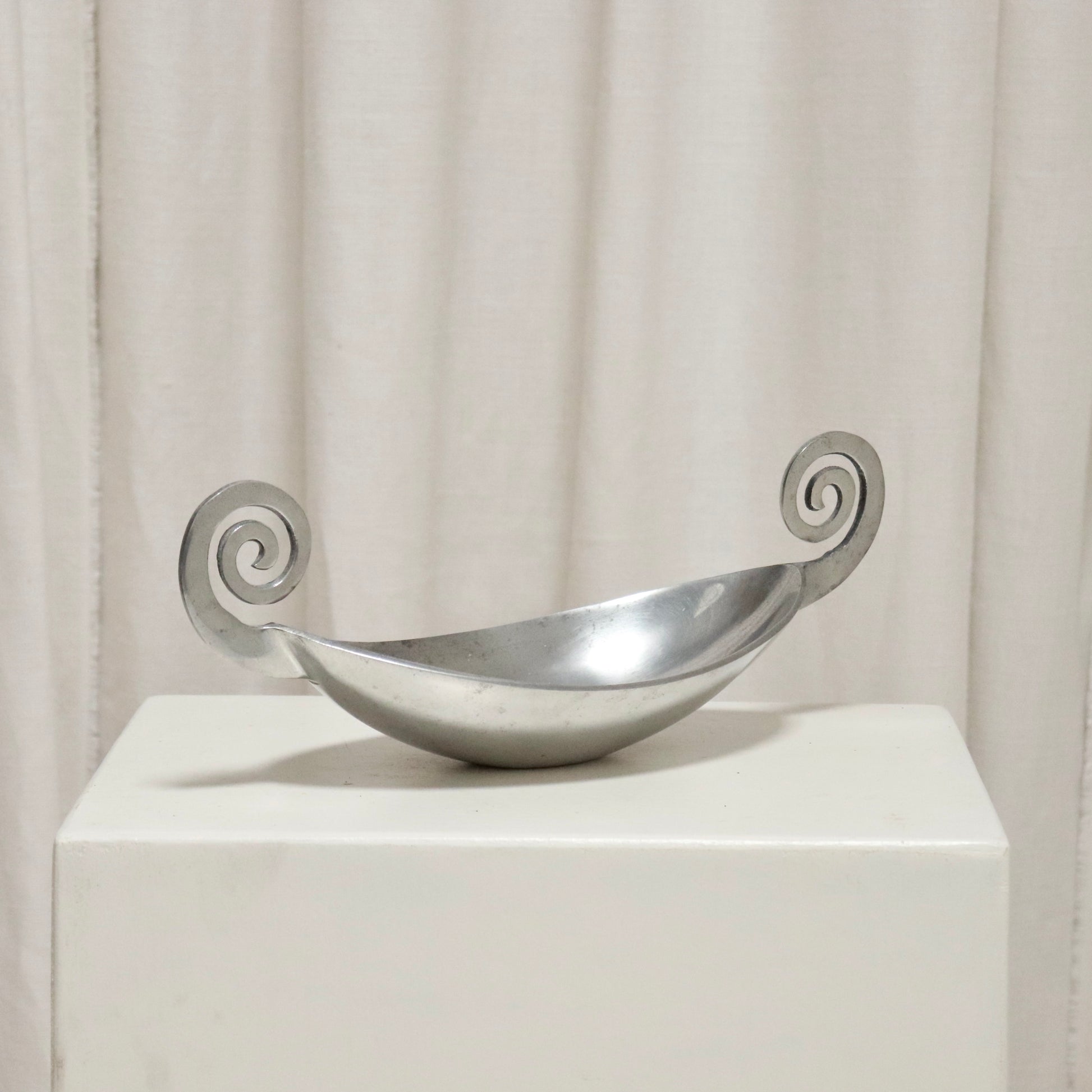 Front view of aluminium dish with twin volute handles.