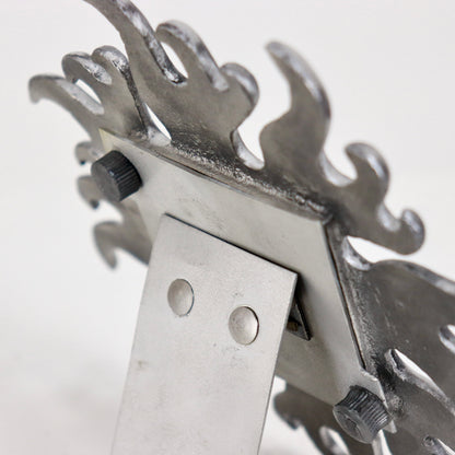 Angled view of small aluminium sunburst mirror on white surface