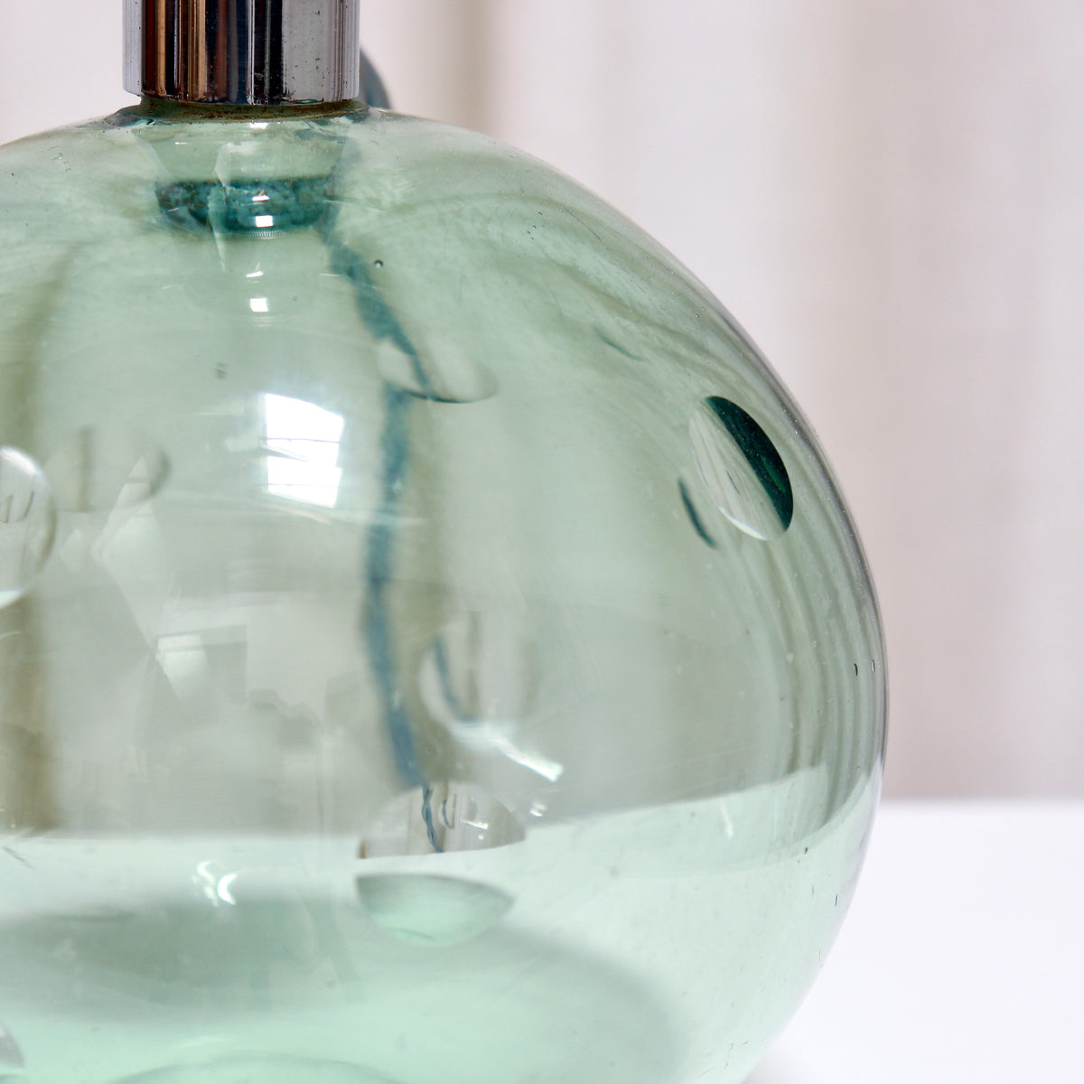Detail of cut dimple decoration on pale green glass lamp
