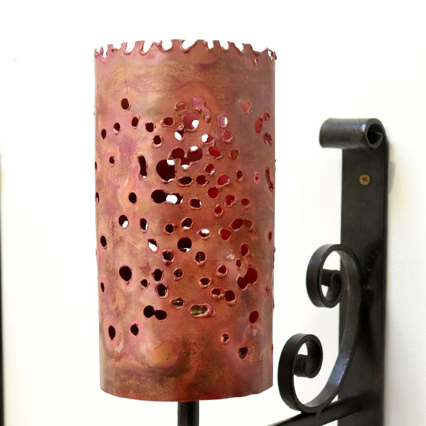 Close-up of heat-patinated copper shade with organic perforations
