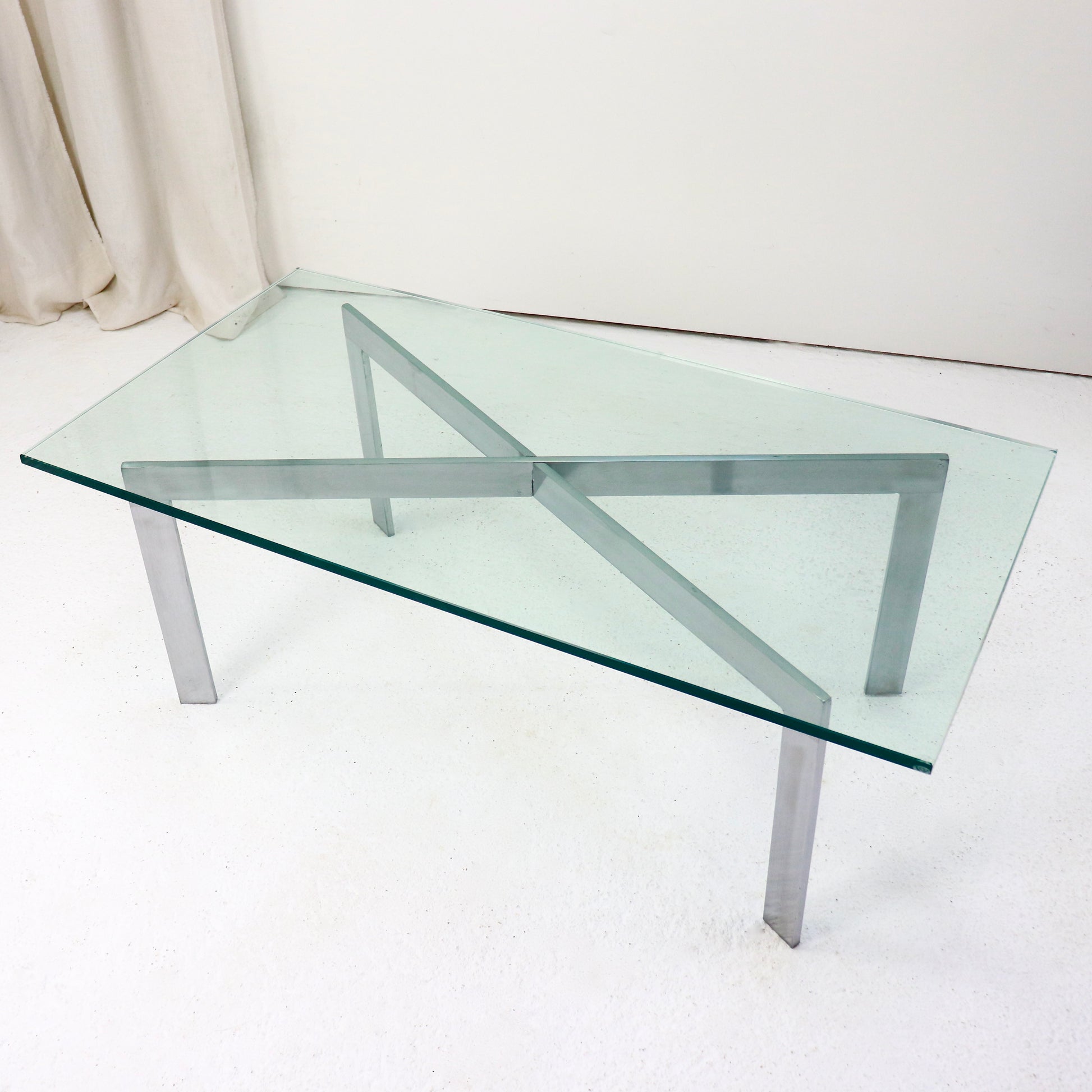 Barcelona-style coffee table with glass top and steel legs