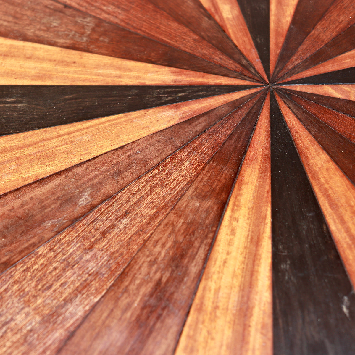 Close-up of the radiating specimen-wood top showing varied grain, colour and surface wear.