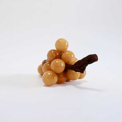 Reverse view of the alabaster grapes showing amber colour variations and a visible line across one grape.