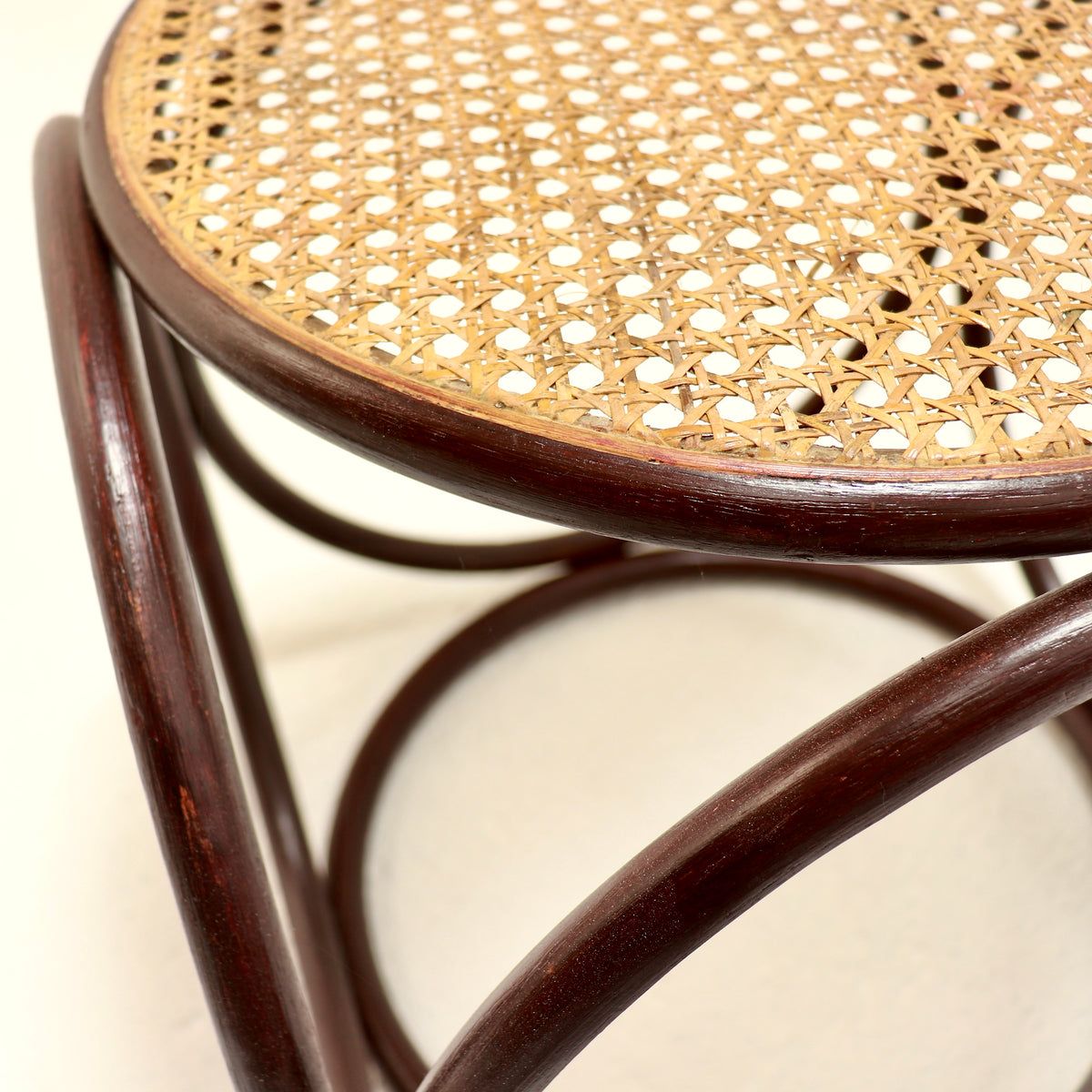 Close-up of the burgundy lacquer and cane seat edge