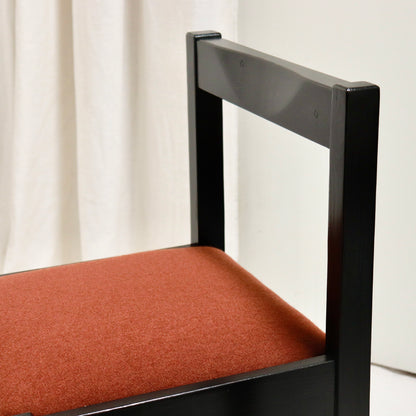 “Close-up of chair back showing dark lacquered pine frame”