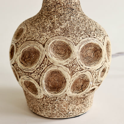 Close-up of textured chalkware surface with carved ring pattern
