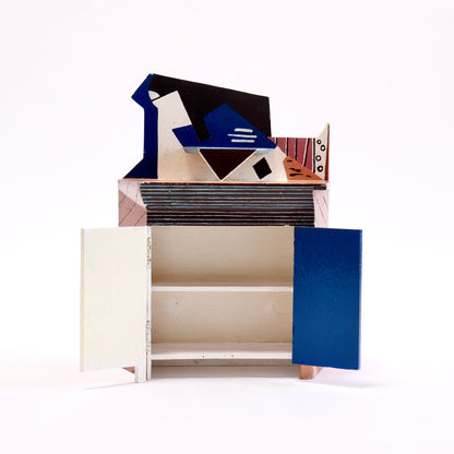 Miniature Picasso-inspired cupboard with both doors open and interior shelf visible