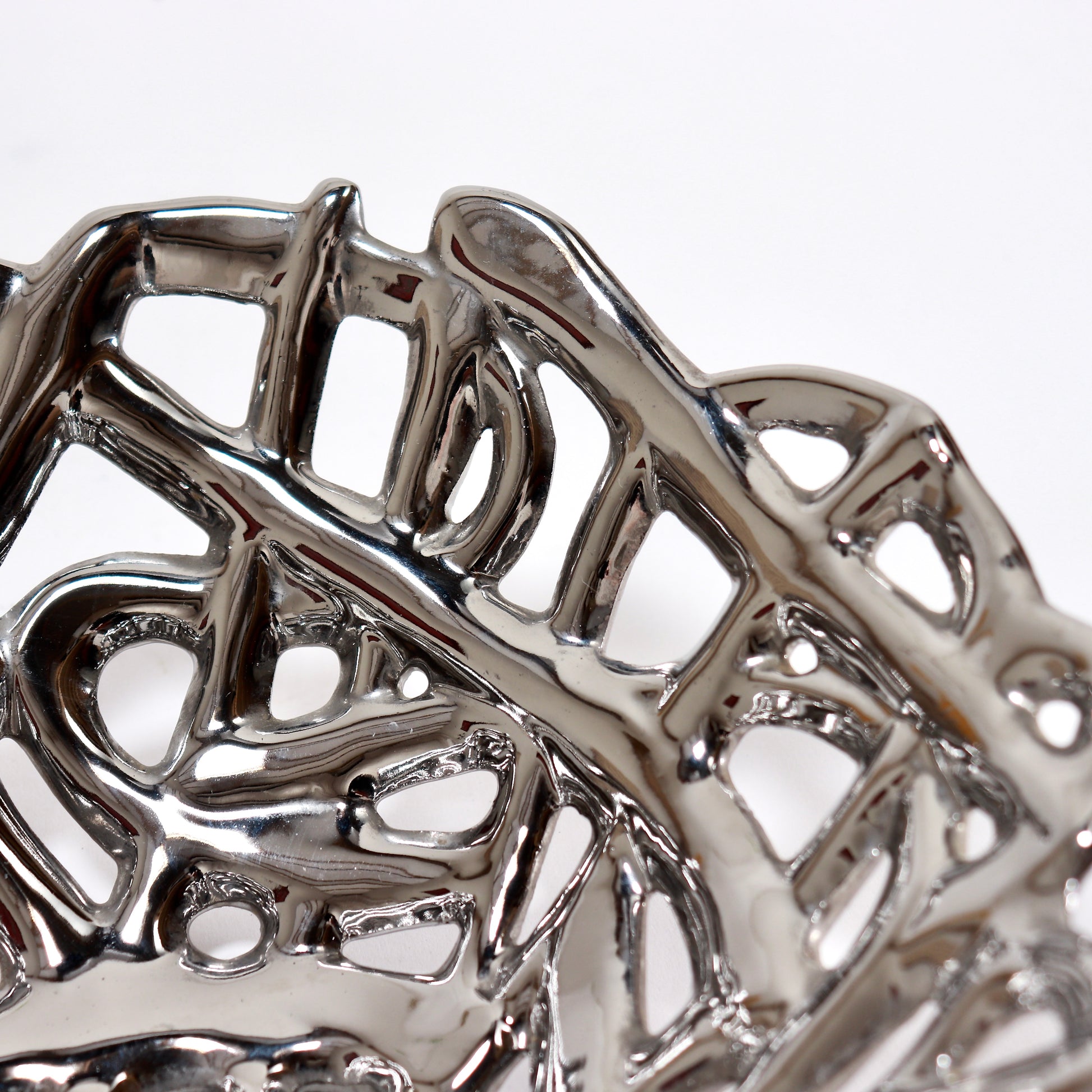 Abstract organic ceramic bowl in polished chrome finish