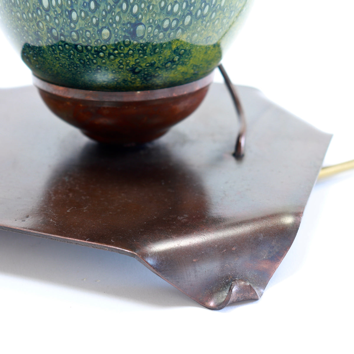 Detail of patinated copper lamp base and folded corners