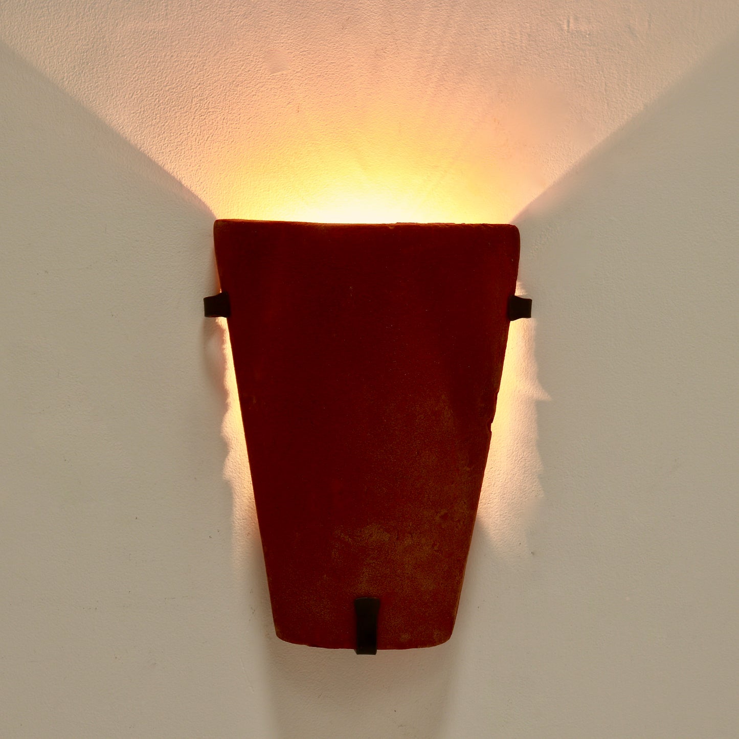 Warm uplight effect from terracotta wall sconce