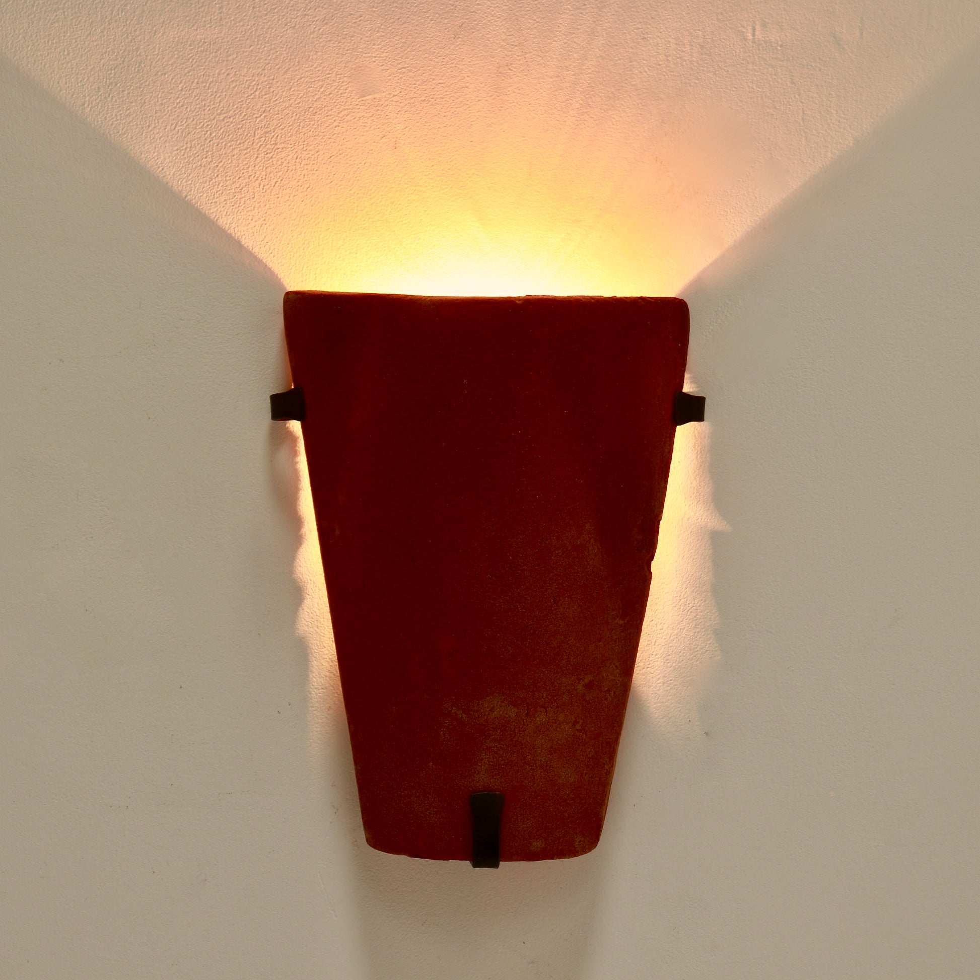 Warm uplight effect from terracotta wall sconce