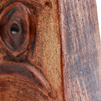 Close-up of the vessel’s ochre and russet surface, showing fine scratches, speckling and dark brown accents.