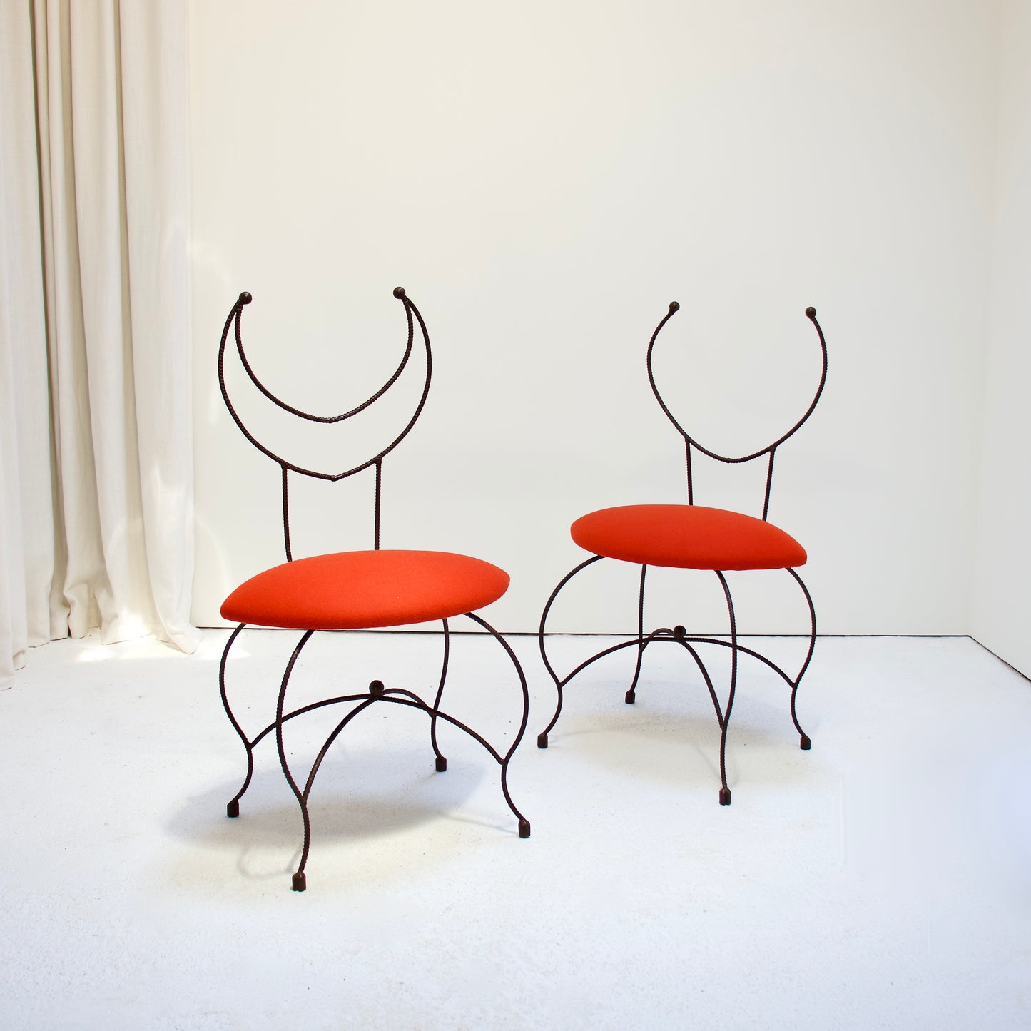Pair of artisan blacksmith-made chairs with red Kvadrat wool seats and sculptural iron frames