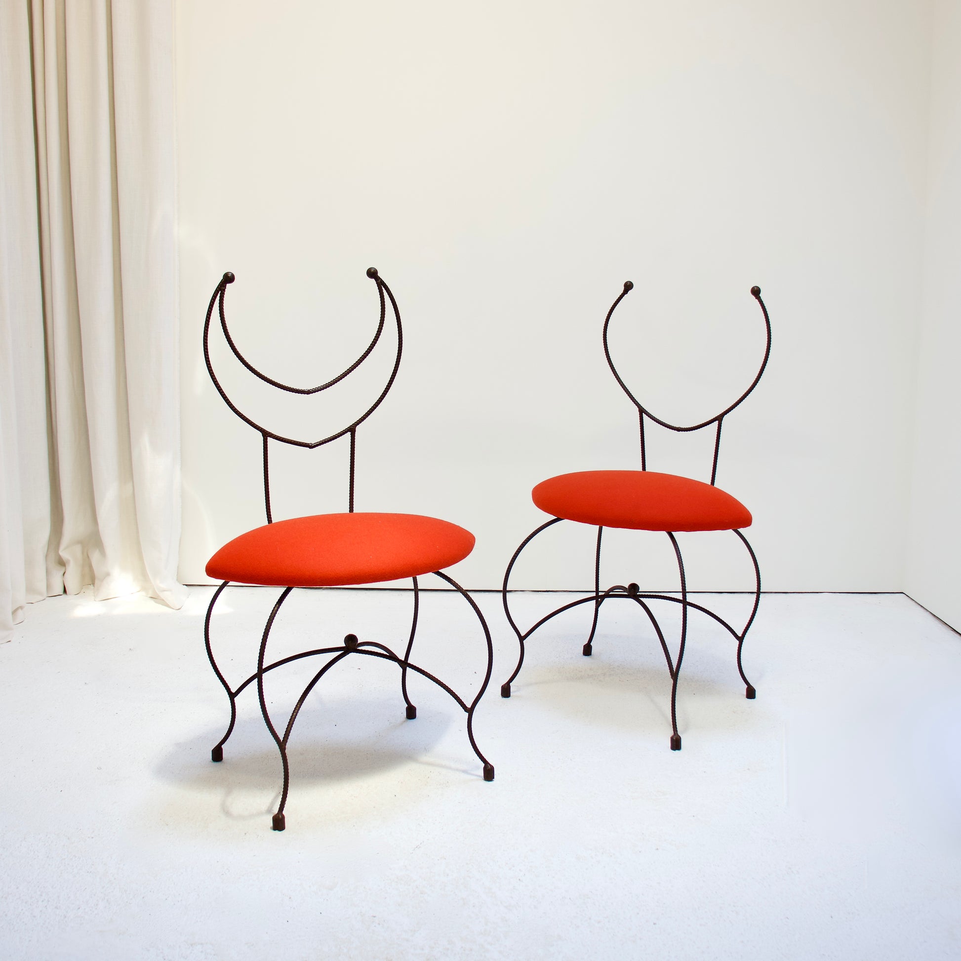 Pair of artisan blacksmith-made chairs with red Kvadrat wool seats and sculptural iron frames