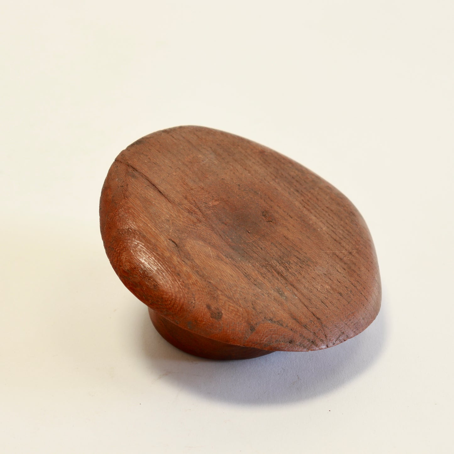 Underside of carved wooden fedora ashtray.