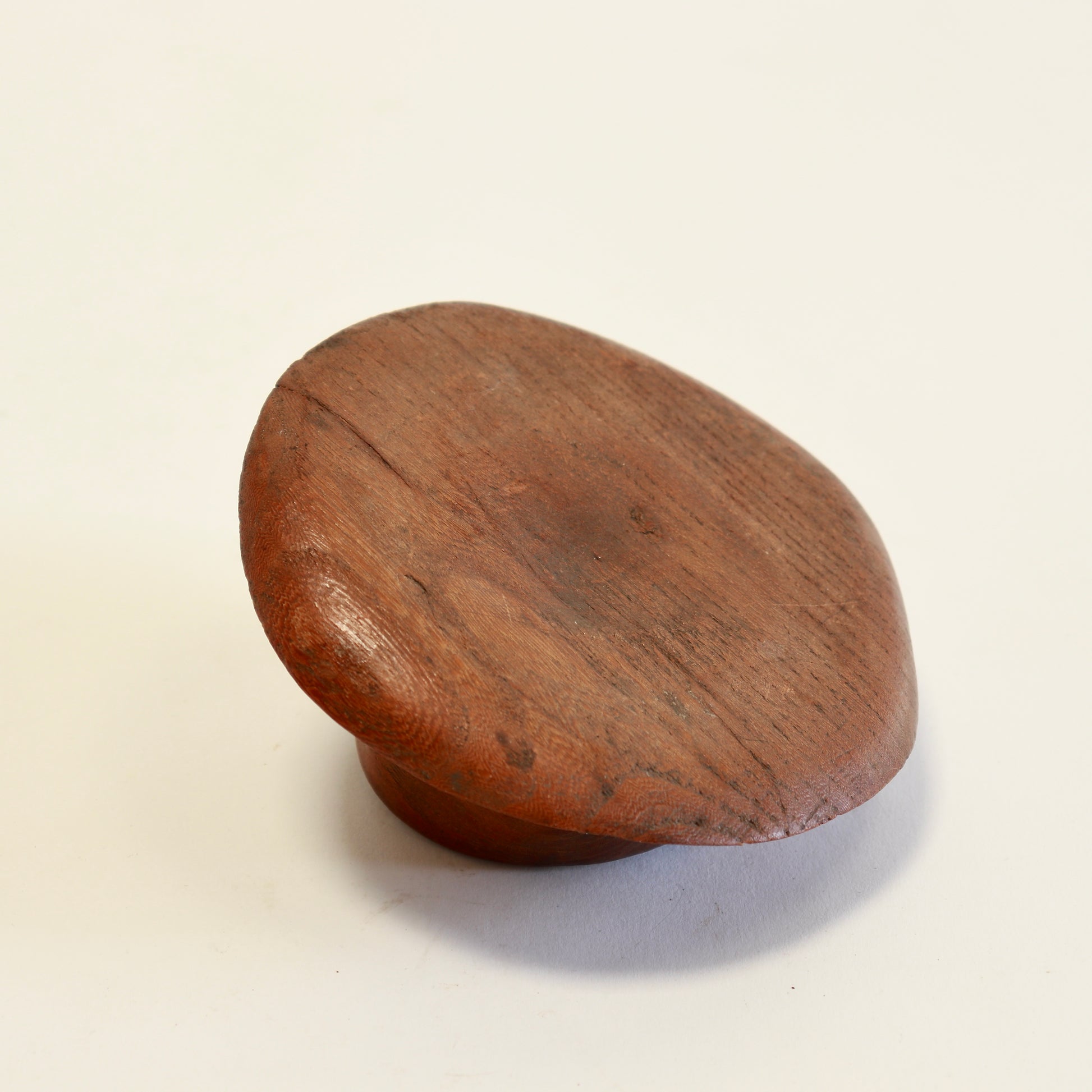 Underside of carved wooden fedora ashtray.