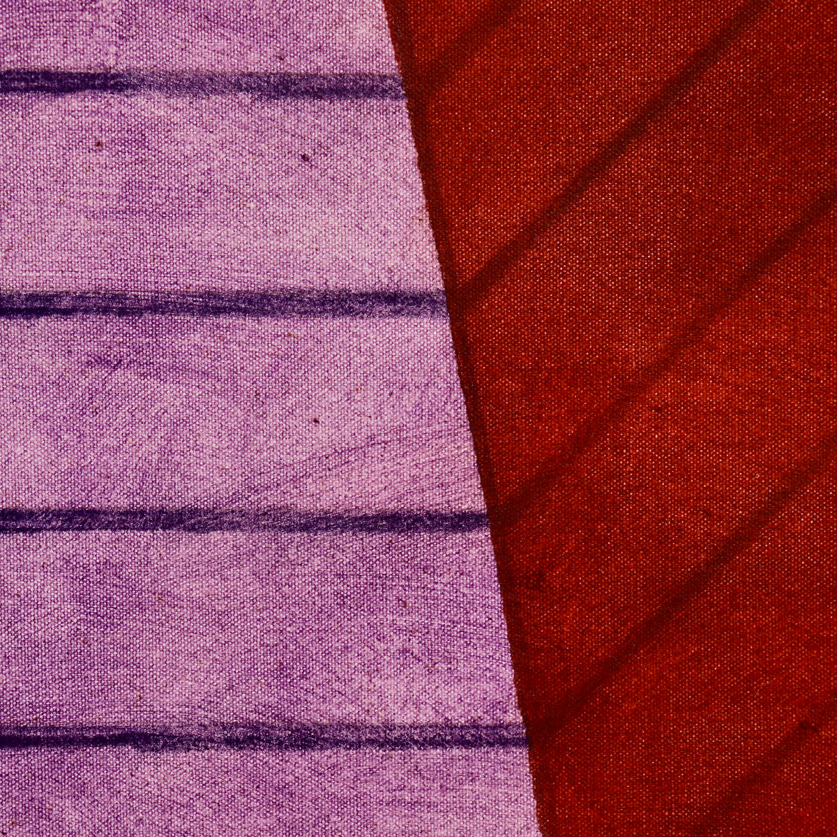 Close-up of dark horizontal and diagonal lines across violet and red painted planes in John Mitchell’s Square Pyramid, Capped.