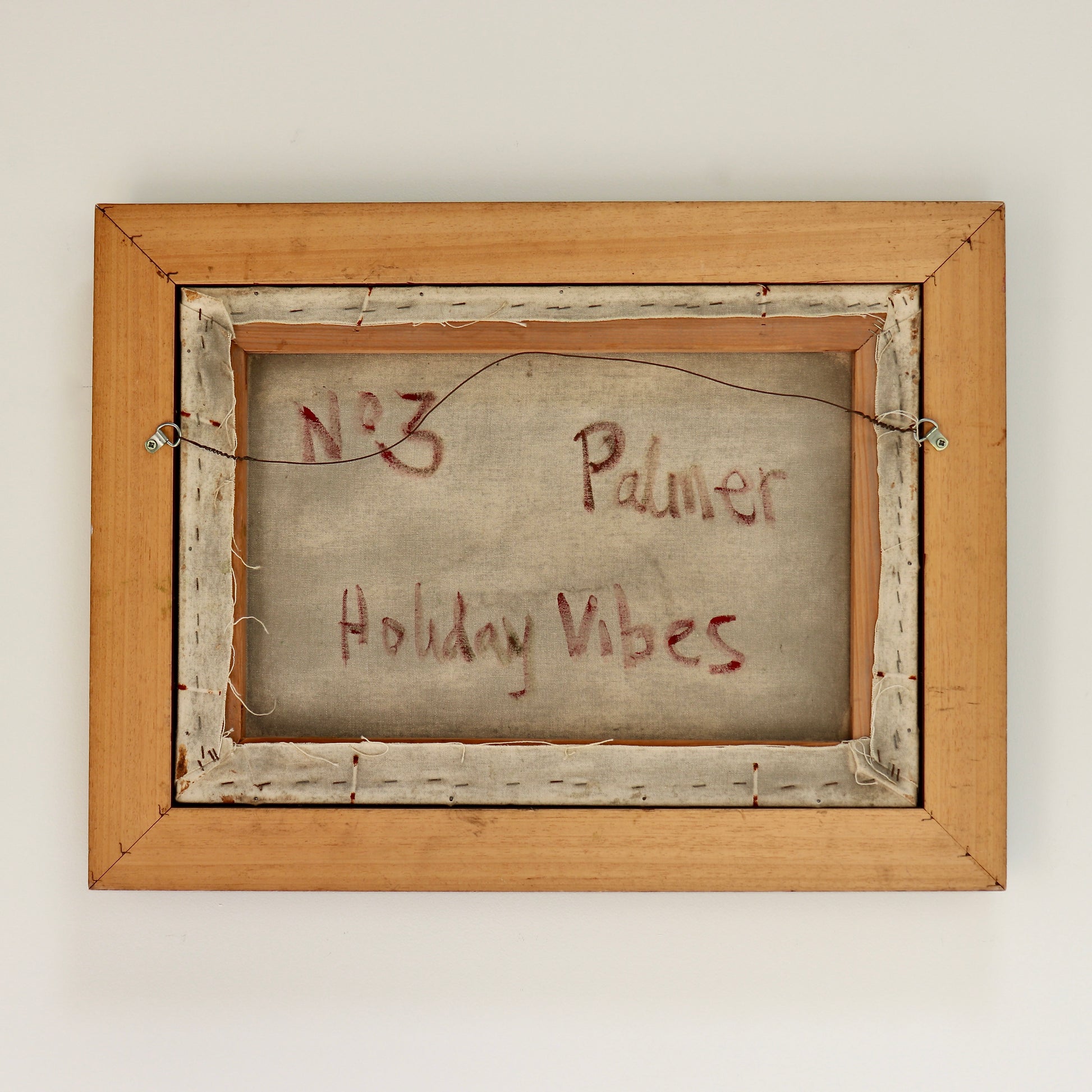 Wooden frame with 'No. 3 Palmer Holiday Vibes' text on a plain background