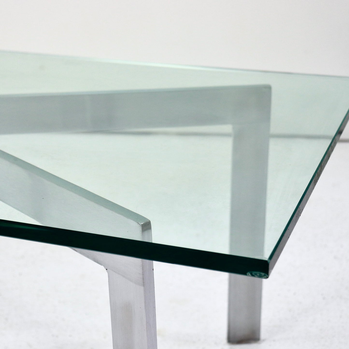 Chamfered glass top on geometric X-frame table