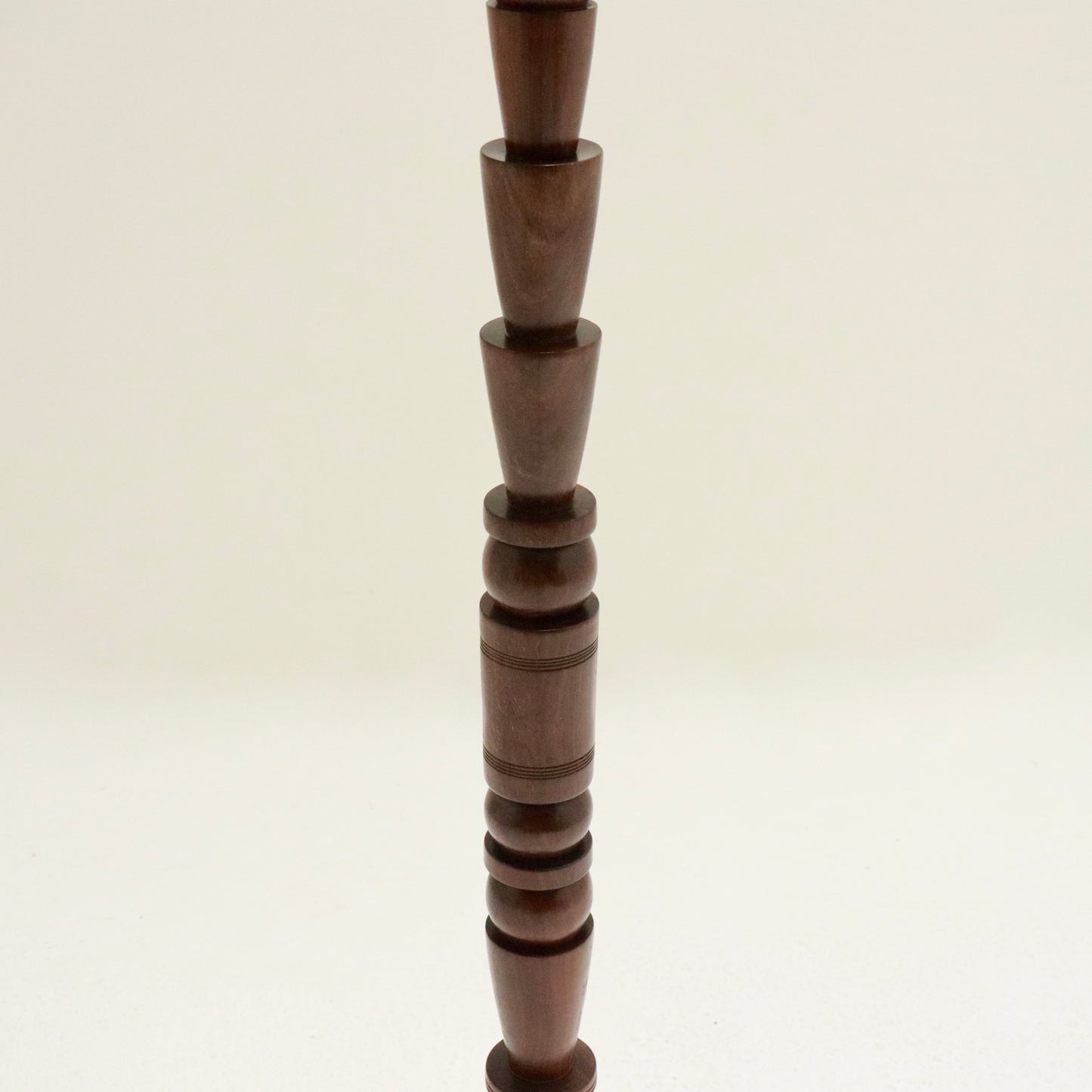 Mid-stem close-up of stacked turned forms.