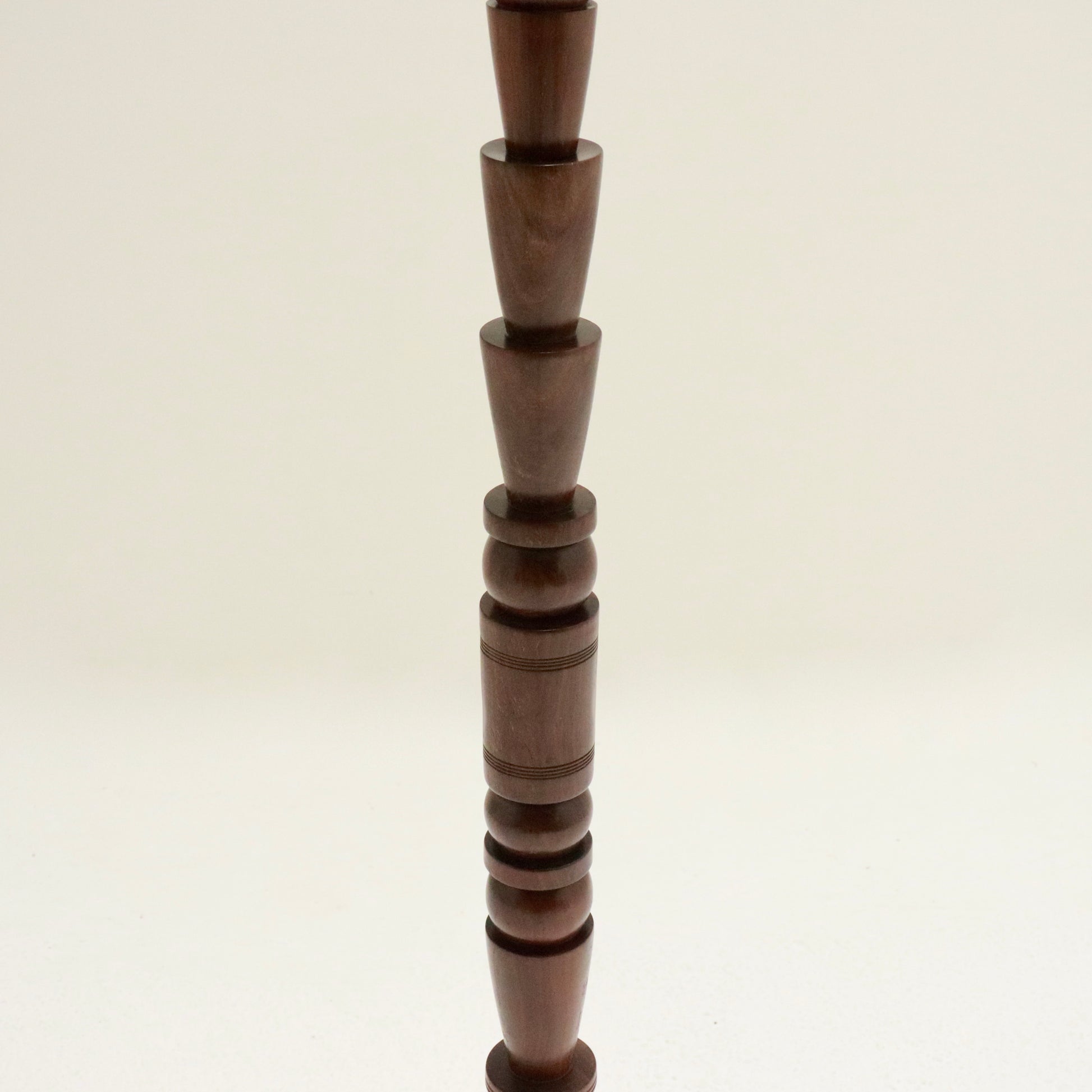 Mid-stem close-up of stacked turned forms.