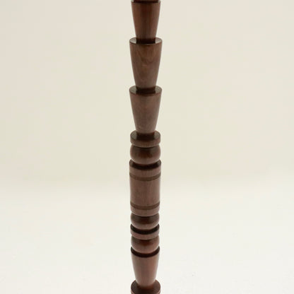 Mid-stem close-up of stacked turned forms.