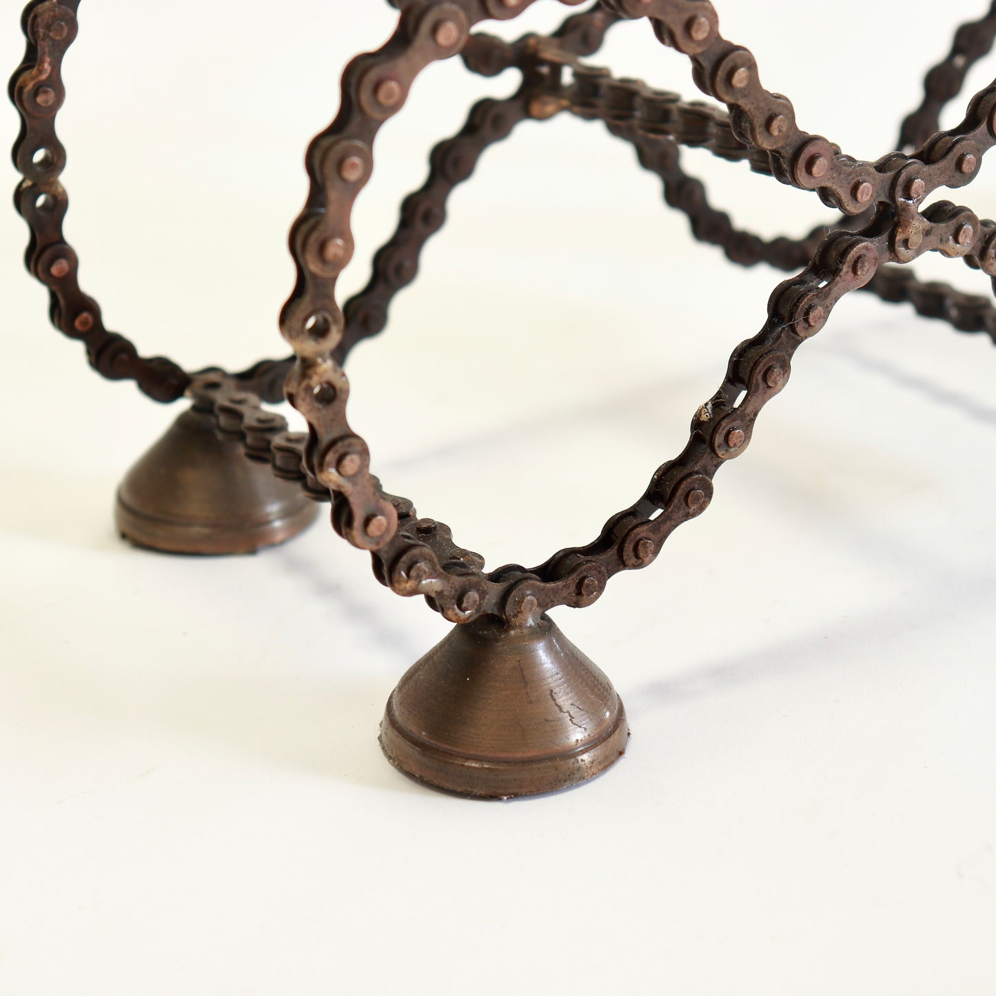 Vintage welded bicycle chain wine rack on metal feet