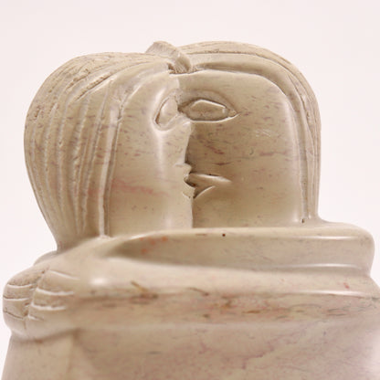 Detailed view of carved faces in soapstone sculpture