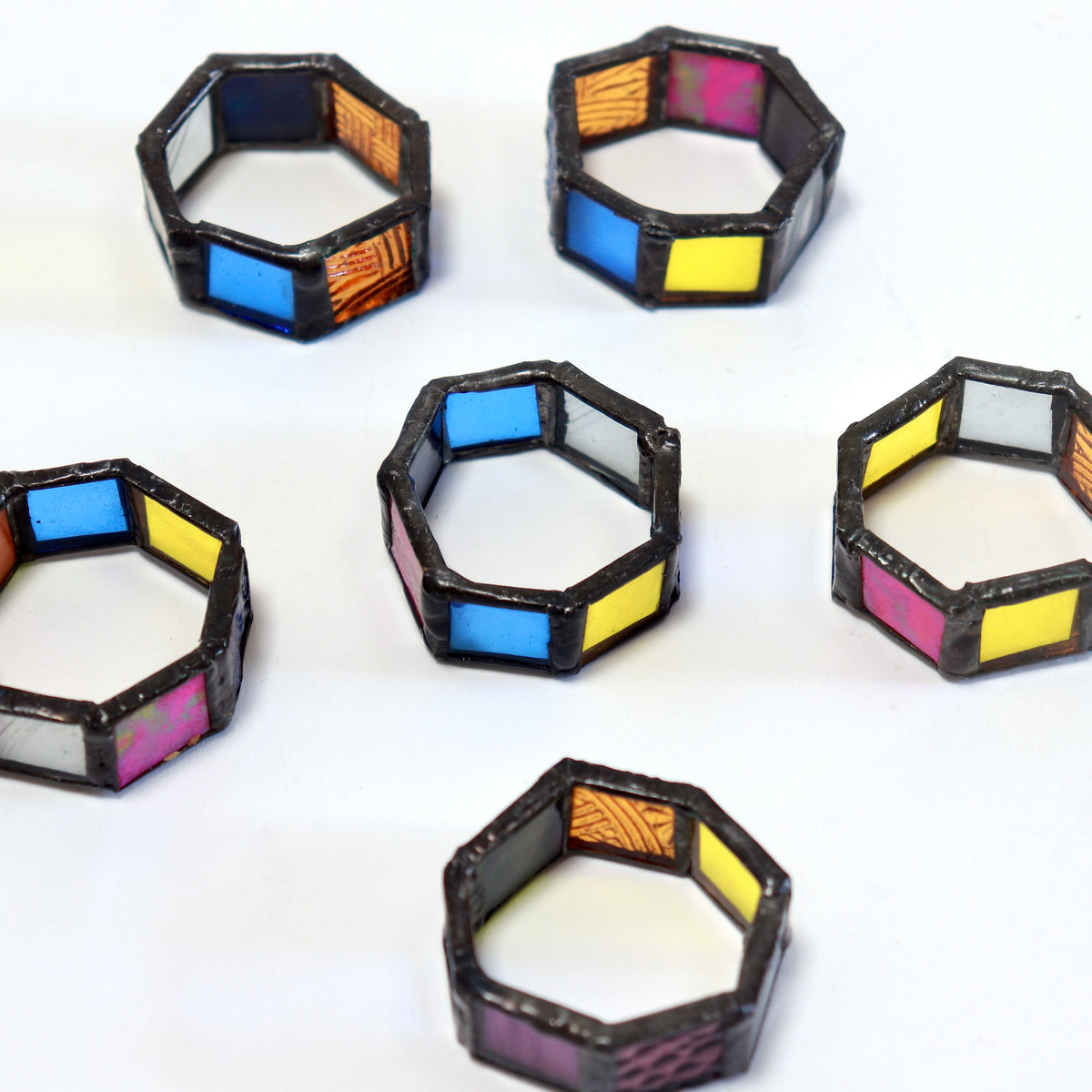 Set of six hexagonal stained glass napkin rings viewed from above