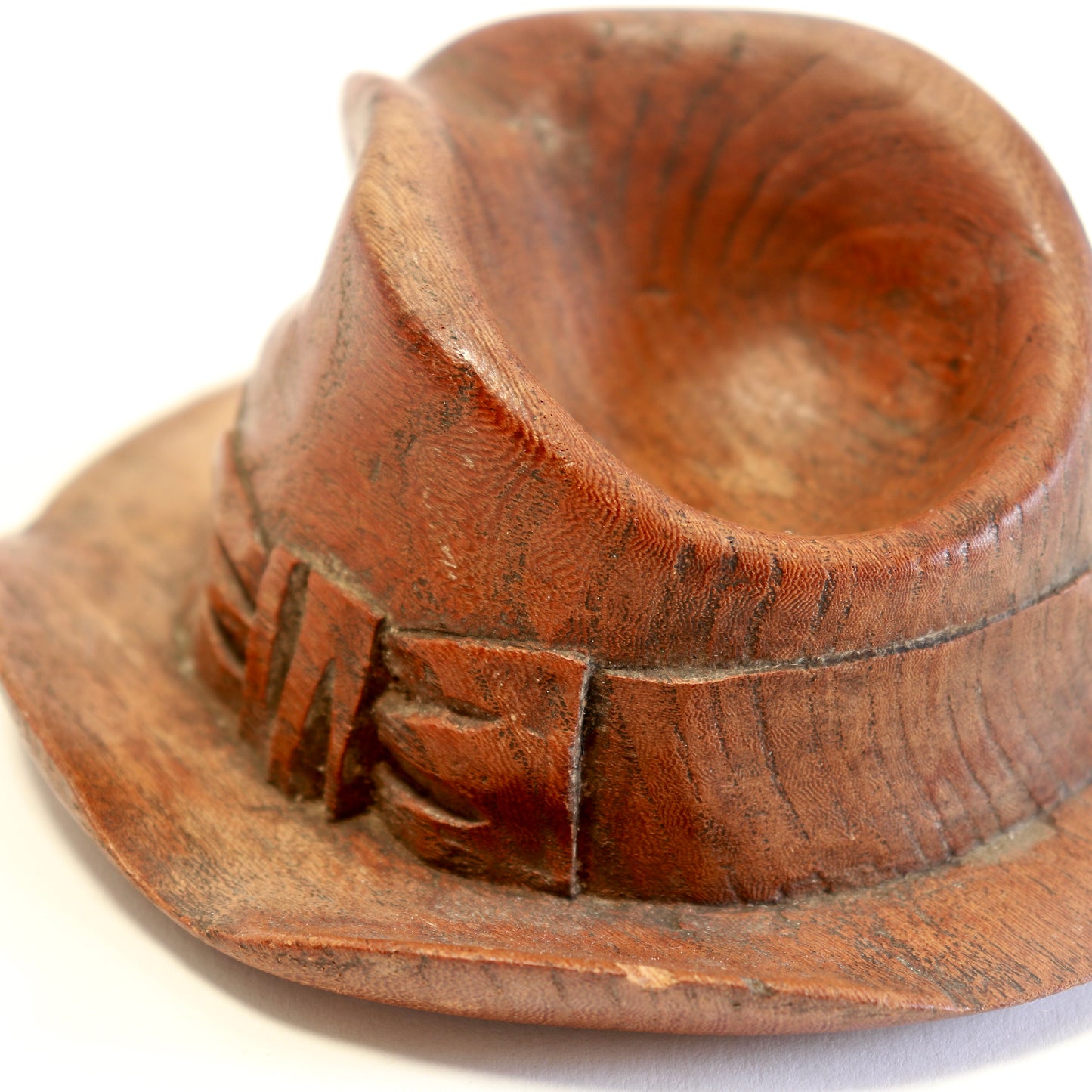 Sculptural carved wooden hat viewed from above.