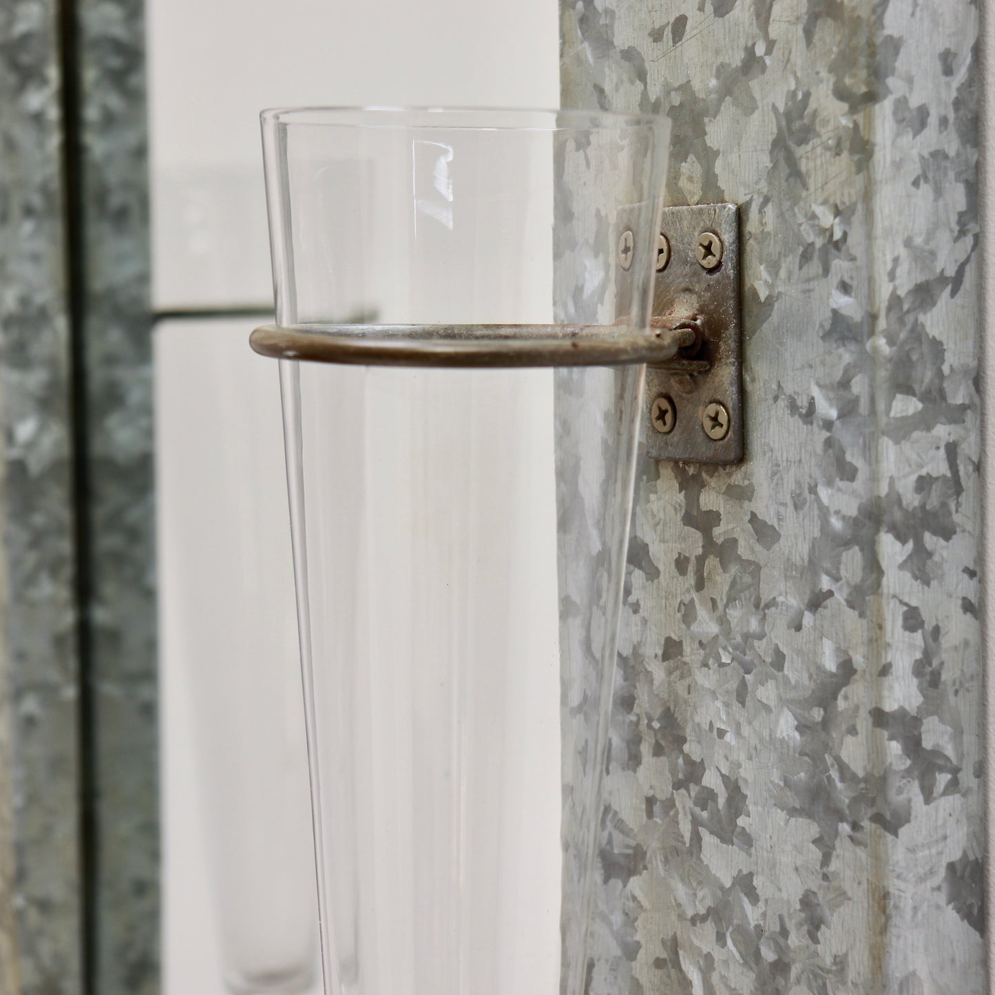 Vintage wall mirror with mounted glass vases detail
