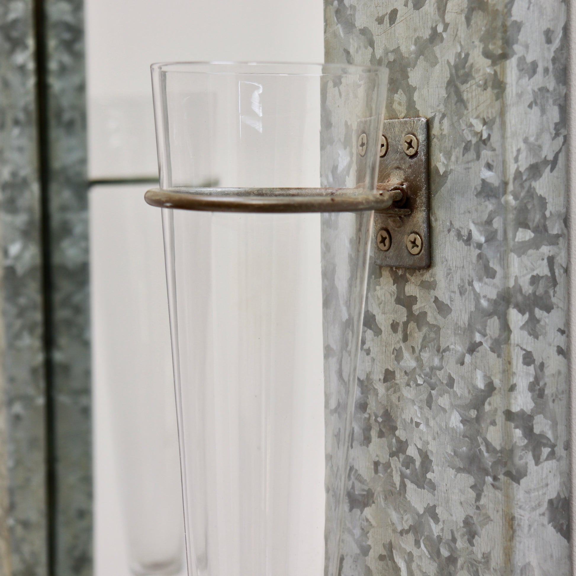 Vintage wall mirror with mounted glass vases detail
