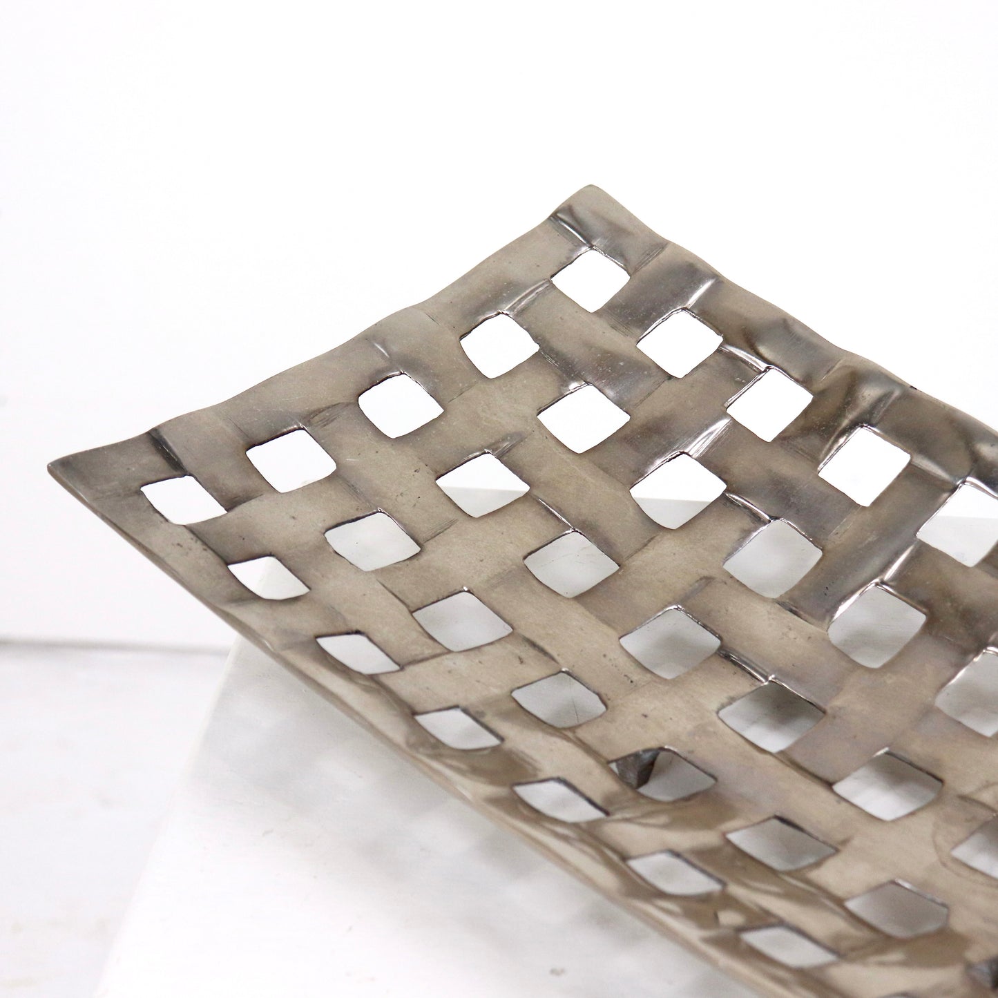 Woven cast aluminium fruit basket with open grid lattice design
