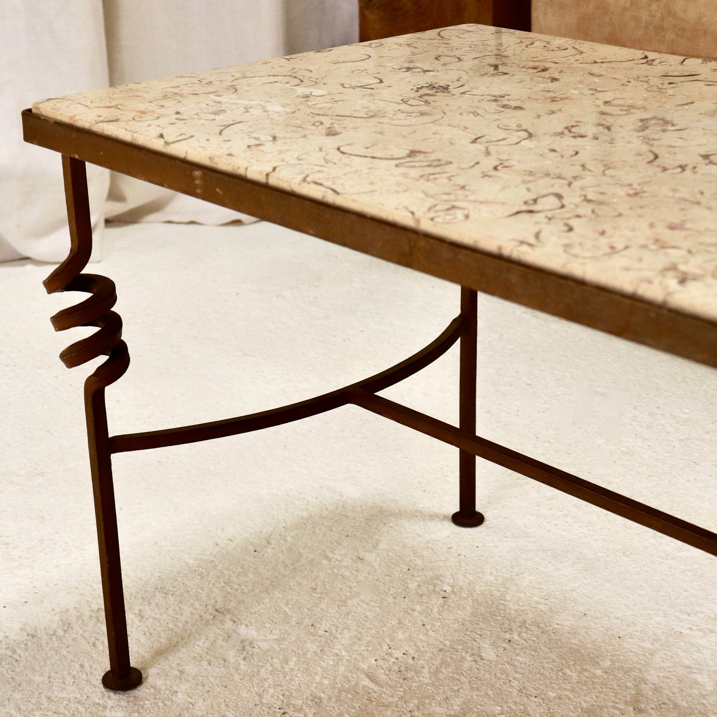 “Vintage coffee table with iron base and spiral detail”