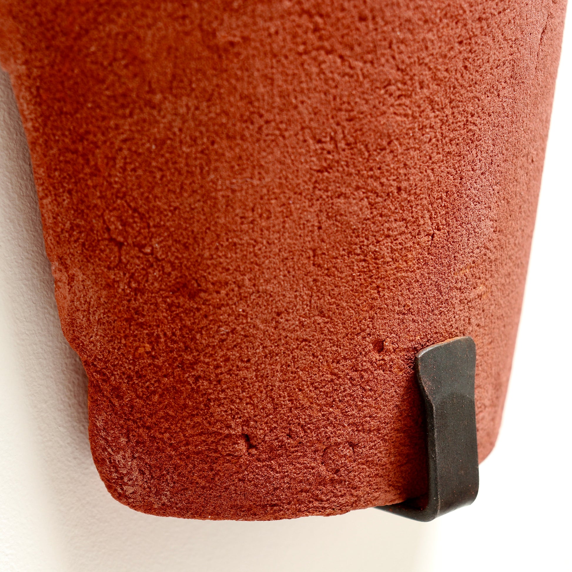 Close-up of terracotta tile wall light with metal bracket