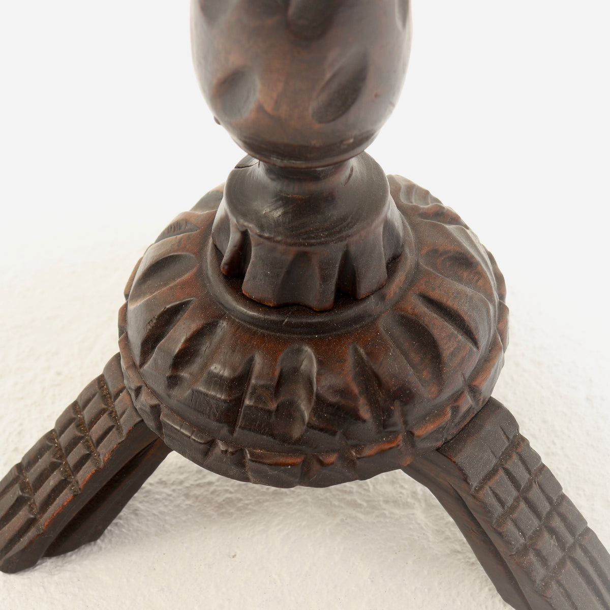 Heavily carved base and three splayed wooden feet
