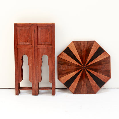 Side table dismantled with its hinged base folded flat beside the removable octagonal top.