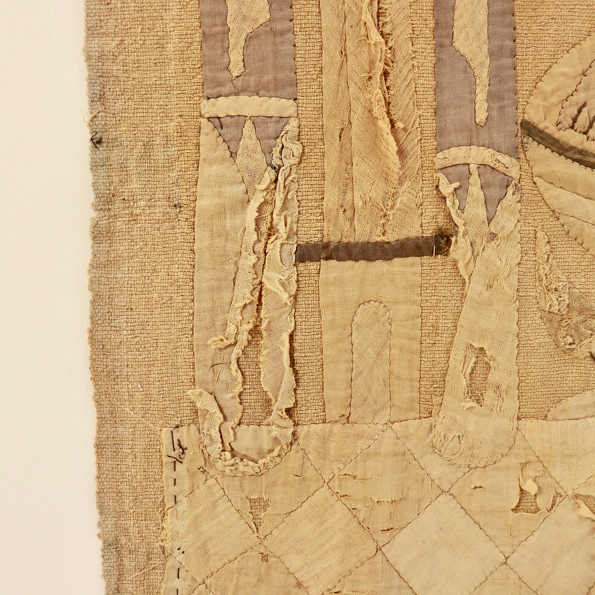 - Detail showing frayed appliqué and losses to the lower design