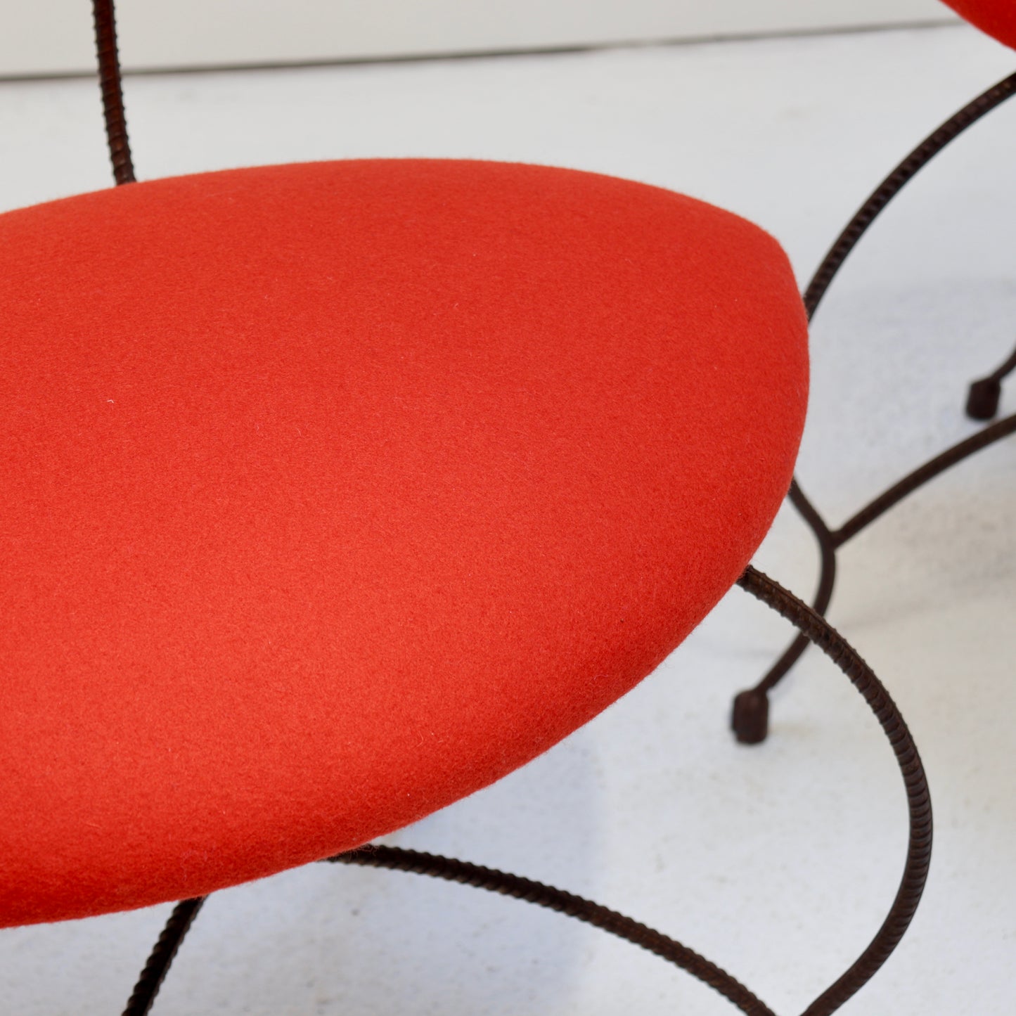 Side view of sculptural artisan iron chair with red Kvadrat seat