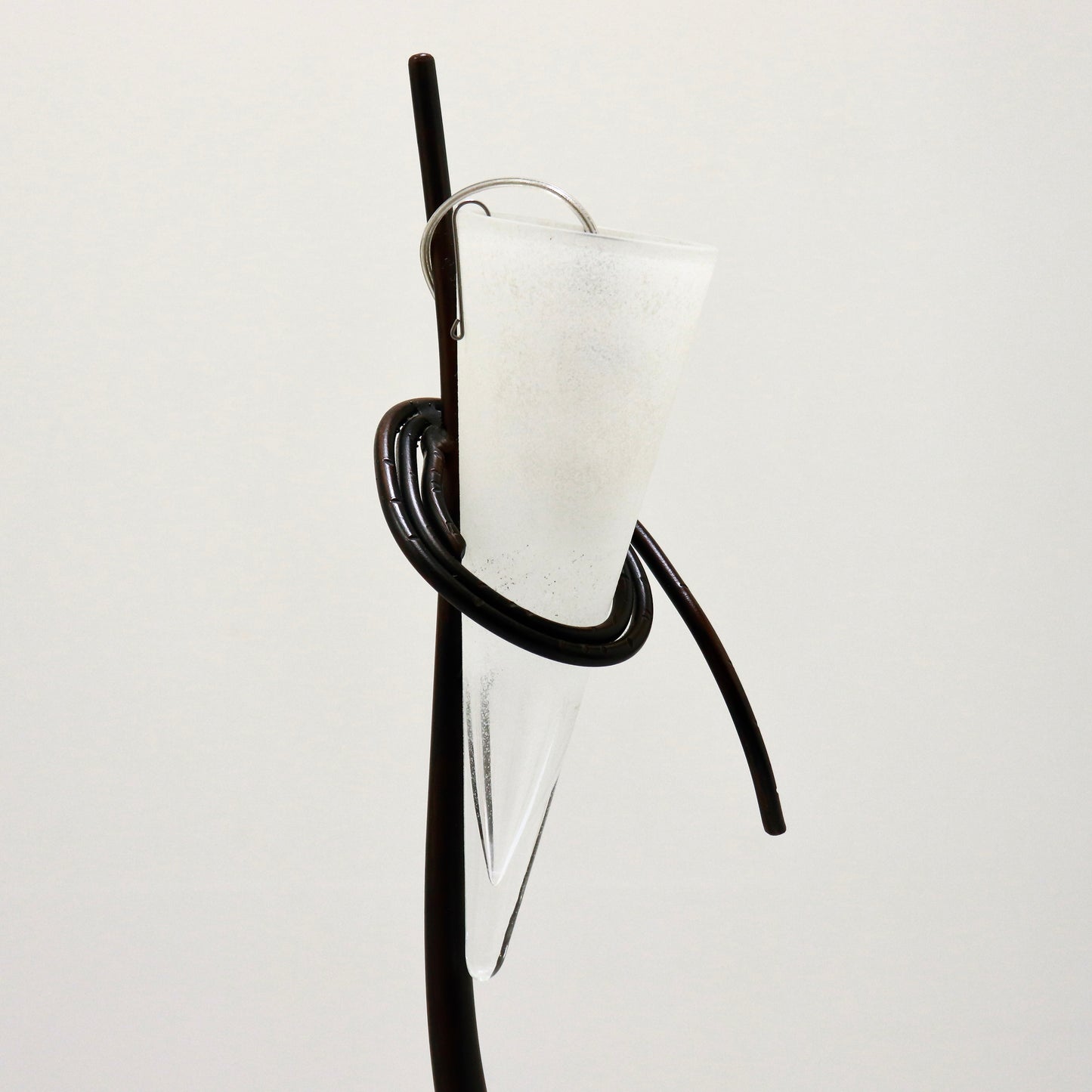 Close-up of coiled iron ring cradling the glass shade.