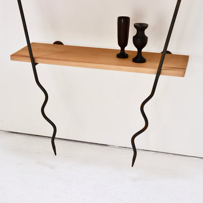 Lower timber shelf styled with dark wooden vessels on the wall system.