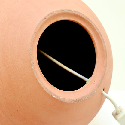 Underside of terracotta lamp showing cable entry