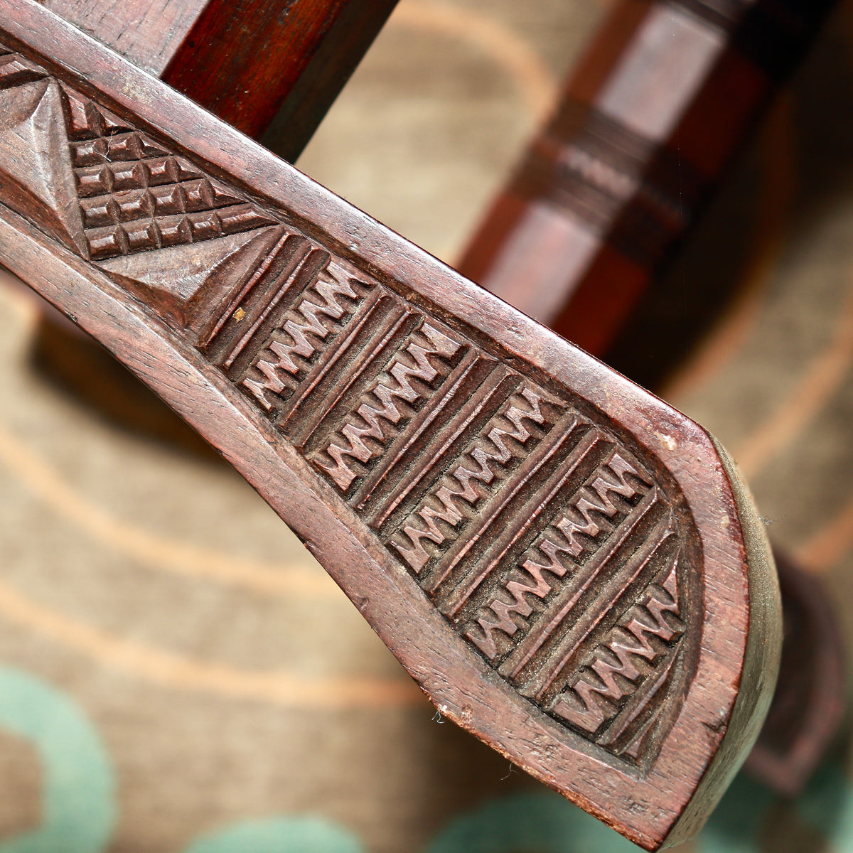 Detail of a trestle foot decorated with rows of chip-carved notches and geometric panels.