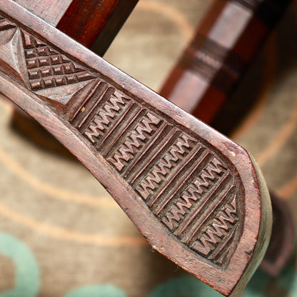Detail of a trestle foot decorated with rows of chip-carved notches and geometric panels.