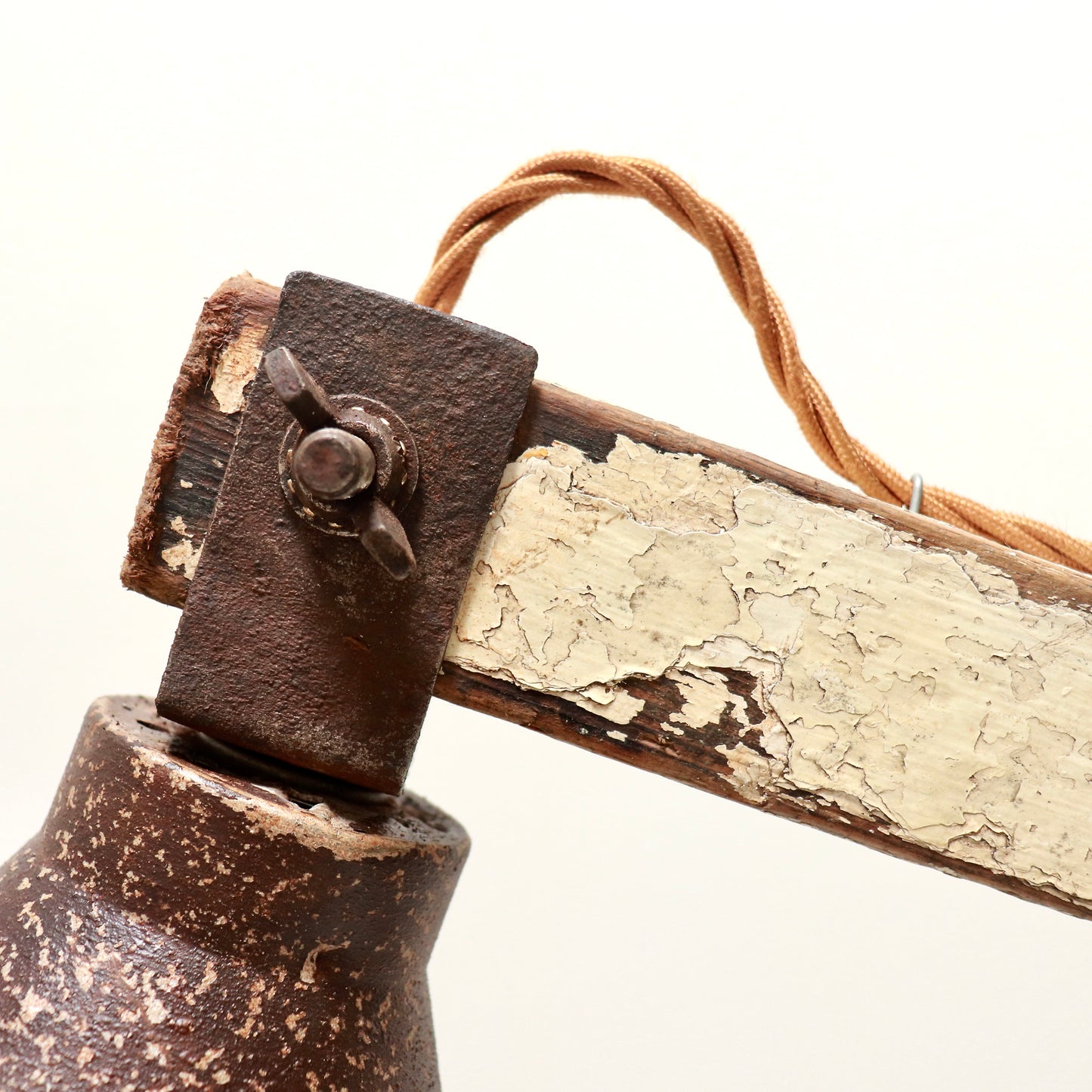 Detail of cracked paint on wooden lamp arm