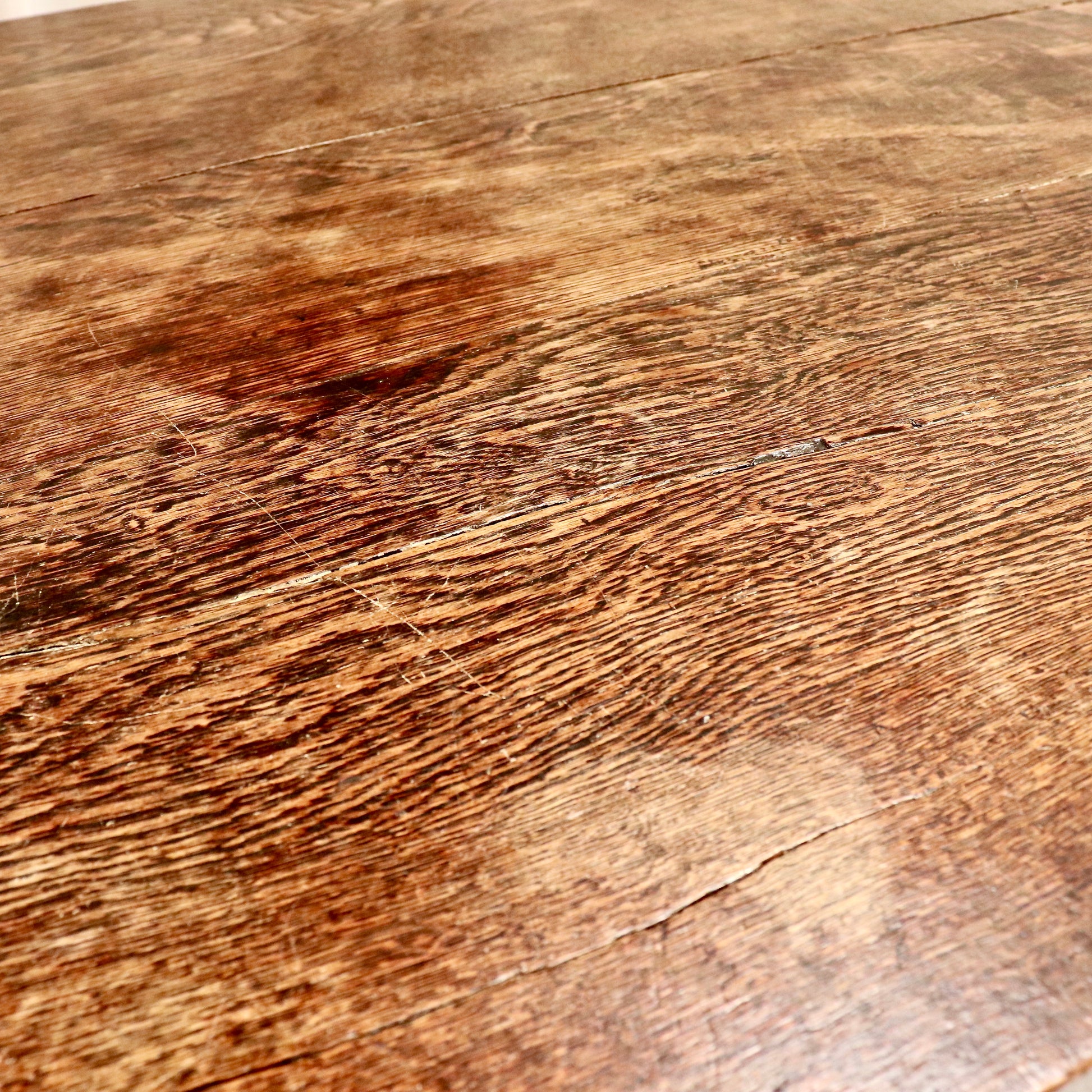 Patina detail with honest wear and colour variation to the oak surface.